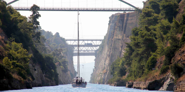 Sailing yachts motoring through the Corinth Canal.