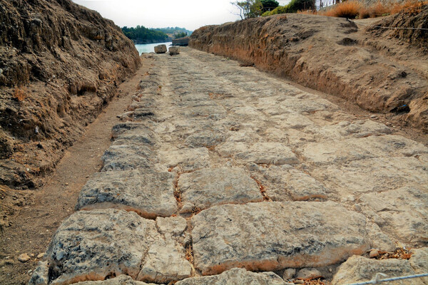 Short section of well-recovered Diolkos, where it is intersected by the canal, note the grooves for the wheels.