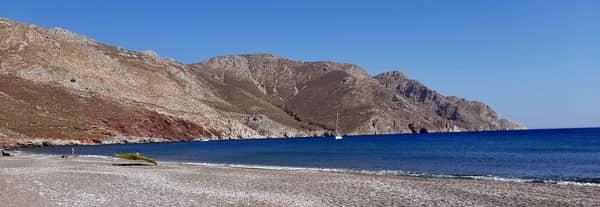 Eristos bay anchorage Tilos with sailing yacht at anchor.